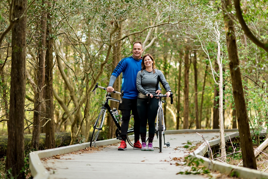 An engaged couple with their bikes on the boardwalk in cape may, nj.